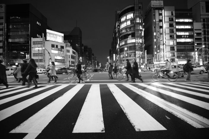Foto Reportage in bianco e nero realizzate in Giappone, Usi e costumi di un popolo, qui in foto i ciclisti attraversano sulle strisce a Tokyo